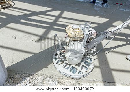 Self leveling power trowel machine sander for smoothing surface to finish concrete slab.