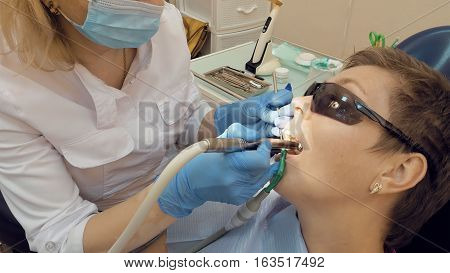 Woman at the dentist clinic office gets dental medical examination and treatment. Odontic and mouth health is important part of modern human life that dentistry help with.
