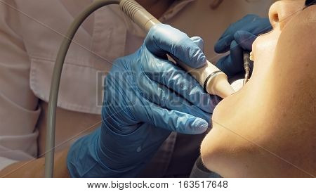 Woman at the dental hygienist and dentist clinic professional tooth whitening and ultrasound cleaning. Odontic and mouth health and hygiene is important part of human life that dentistry help with.