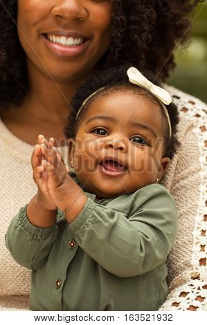Happy African American mother and daughter playing.