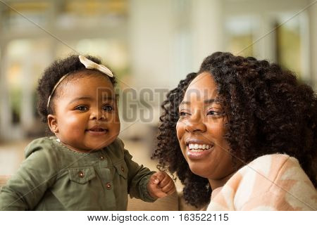 Happy African American mother and daughter playing.