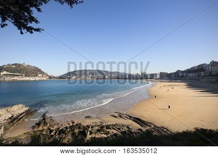 DONOSTI-DECEMBER 22 2014: On sunny days the people of Donosti take the opportunity to stroll along La Concha Beach in Donosti, Spain on December 22,  2014