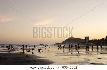 People Playing On The Beach At Sunset