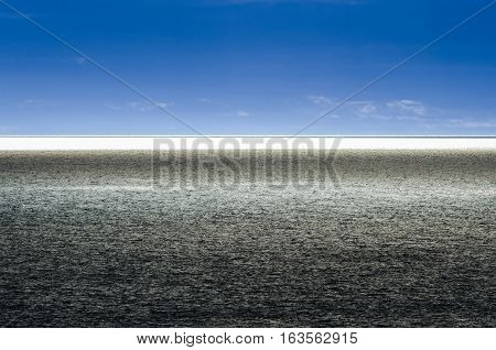 Dramatic split blue horizon on the sea.  Sun shines on the Ocean, High contrast, Atlantic Ocean at Twillingate, dramatic blue sky, water reflects brilliant sunshine