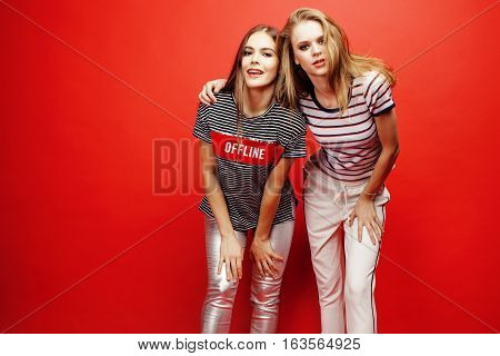 two best friends teenage girls together having fun, posing emotional on red background, besties happy smiling, lifestyle people concept close up