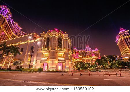 Macau, China - December 8, 2016: scenic view of pink and gold colors of Galaxy Macau Casino hotel in Cotai Strip, during the laser show. Macao typical street scene of nightlife.