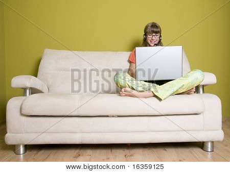 Teenager mit Laptop auf sofa