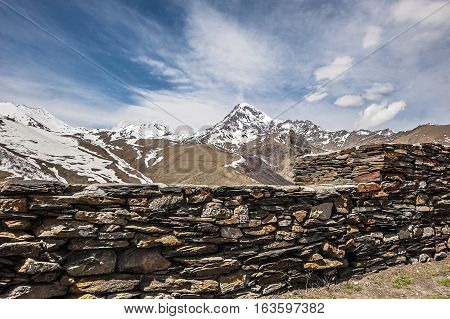 Georgia . Stepantsminda village . Gergeti Sameba Orthodox church on a background of mountain spring .