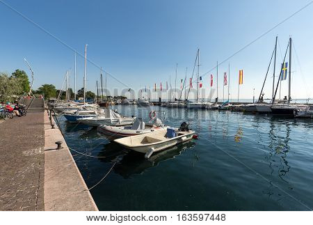 BARDOLINO, ITALY - MAY 4, 2016: Sailboats and fishing boats at Porto di Bardolino harbor on The Garda Lake . Italy