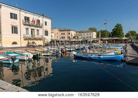 BARDOLINO ITALY - MAY 4 2016: Sailboats and fishing boats at Porto di Bardolino harbor on The Garda Lake . Italy