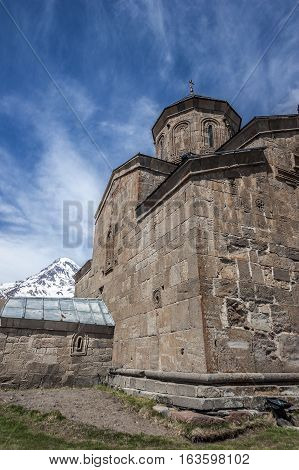 Georgia . Stepantsminda village . Gergeti Sameba Orthodox church on a background of mountain spring .
