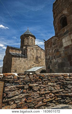 Georgia . Stepantsminda village . Gergeti Sameba Orthodox church on a background of mountain spring .