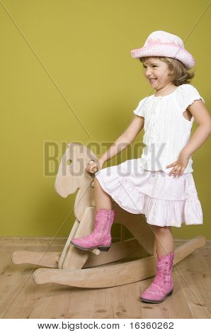 Kleine Mädchen und Schaukelpferd