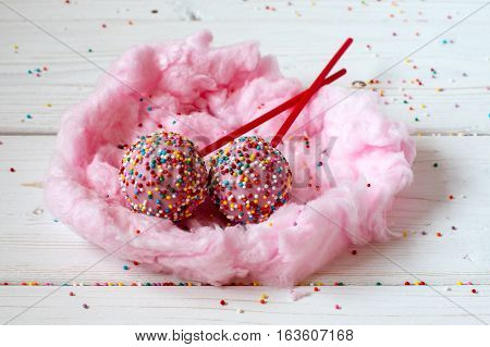 Cakepops in the nest made from candy-floss, white background