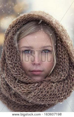 Winter Portrait Of Attractive Young Blonde Girl Wearing Knitted Snood Covered In Snow.