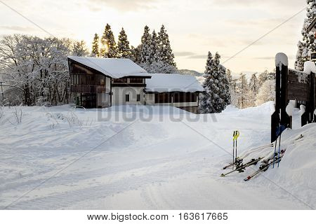 Myoko ski lodges during early morning sunrise.  Low cloud cover hovers over the lower parts of town. There are no people to be seen at this time of day.