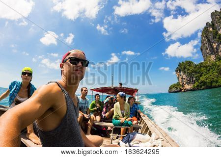 KRABI THAILAND 30 OCTOBER 2012 : Company of young people going to adventure to Tonsai and Railay beaches at Krabi Province by traditional thai longtail boat.