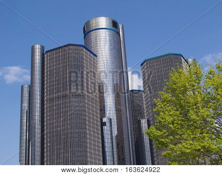 DETROIT - May 3, 2016. The top of a tree with spring leaves is seen with the interconnected towers of the Renaissance Center, located in downtown Detroit. Built in 1977, the RenCen, as it is often called, is the tallest building in Michigan.