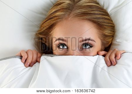 Beautiful Blonde Woman Hiding Face Under Cover Lying In Bed