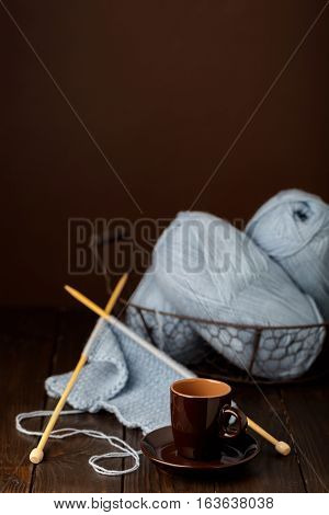 Knitting from light blue yarn and a cup of coffee.