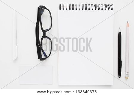 Blank notebook with stationery and glasses flat lay mockup. Top view on writer with bad vision work tools, free space. Art, business, creation, imagination, stationery, workplace, orderliness concept