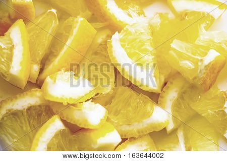 Finely chopped pieces of lemon. Lemon pieces in different sizes background.