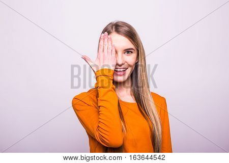 Happy Blonde Girl In Orange T-shirt Close One Eyes With Hand On White
