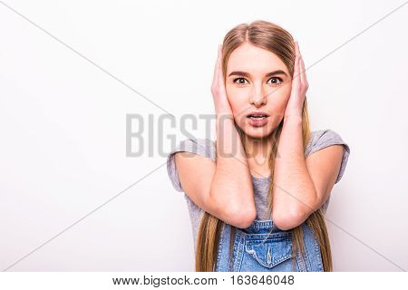 Girl close her ears with hands in white