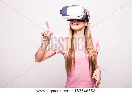 Joyful young girl using a VR headset and smiling isolated on white background