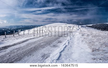 winter hiking trail with nice sky and snow near Pretulalpe hill in Stuhleck mountain ridge in Fischbacher Alpen mountains in Styria