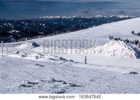 winter austrian alps panorama with Hochschwab, Seckau Tauern and Ennstal Alps from Pretulalpe hill in Fischbach Alps in Styria with snow and blue sky with clouds
