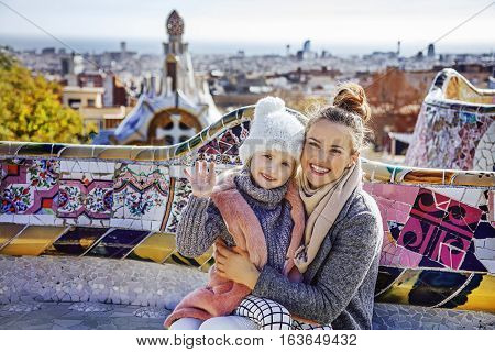 Mother And Child In Barcelona Handwaving While Sitting On Bench
