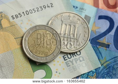 Greek Drachma and euro coin on bank note