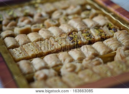 Macro detail of typical Arabian sweets(asabe, balluriah, eschkajoo, turkiya) set in rows of different kinds of eastern pastry