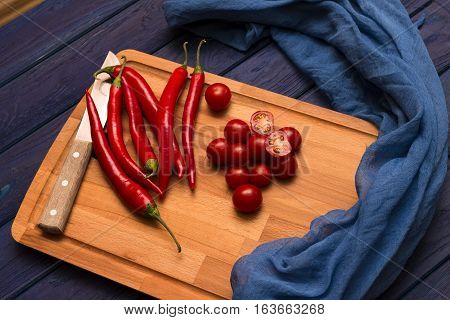 red chili pepper on the wood blue table with the shawl and knife