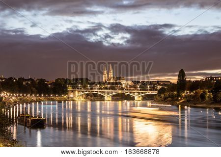 Basel, Switzerland - October 20, 2016: Night view of the Rhine River with the illuminated Basel Minster
