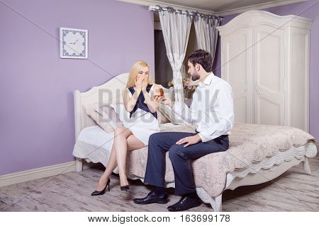Handsome man doing a marriage proposal while offering his wife an engagement ring. Boyfriend make a marriage proposal to his girlfriend in valentine days.