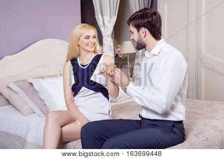 Handsome man doing a marriage proposal while offering his wife an engagement ring. Boyfriend make a marriage proposal to his girlfriend in valentine days.