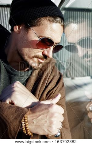 Handsome man in sunglasses on the streets of a big city. Reflection.