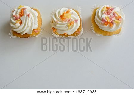 Two vanilla cupcakes on the white table