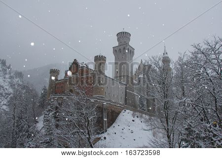 Fussen Germany - December 26 2014: view of Neuschwanstein Castle in winter time between trees on December 26 2014 near Fussen Germany.