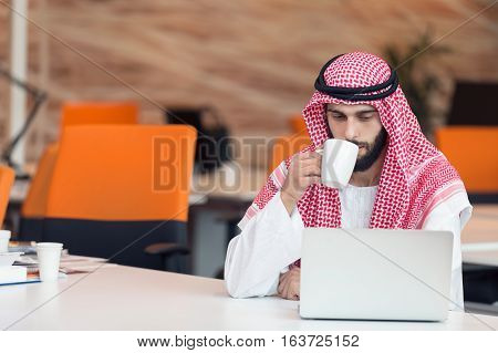 Arabian businessman working in modern startup office.