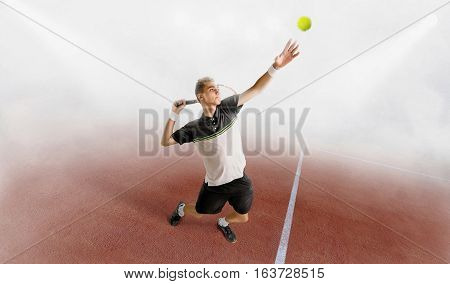 young man play tennis outdoor on orange tennis court at early morning in a fog