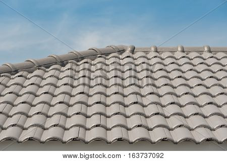 Rows of roof tiles on the top of house with sky background.
