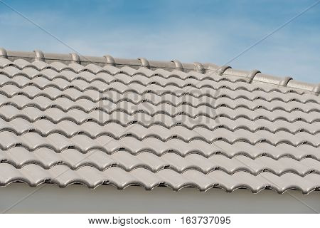 Rows of roof tiles on the top of house with sky background.