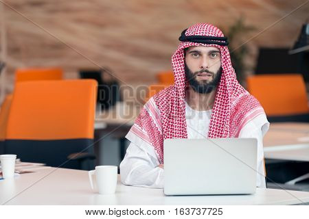 Arabian businessman working in modern startup office.