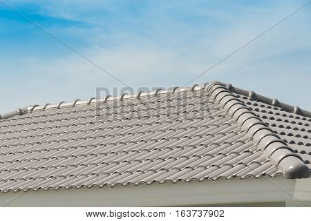 Rows of roof tiles on the top of house with sky background.