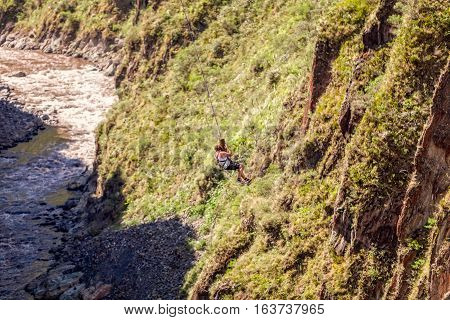 Young Man Hanging On A Rope After The Bungee Jump Against The Pastaza River Banos De Agua Santa Ecuador South America