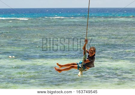 Lavena, Fiji - November 27: Unidentified Boy Swings On A Rope Swing On November 27, 2013 In Lavena V