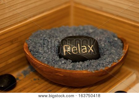 black lava stones massage and a wooden bowl with lavender salt